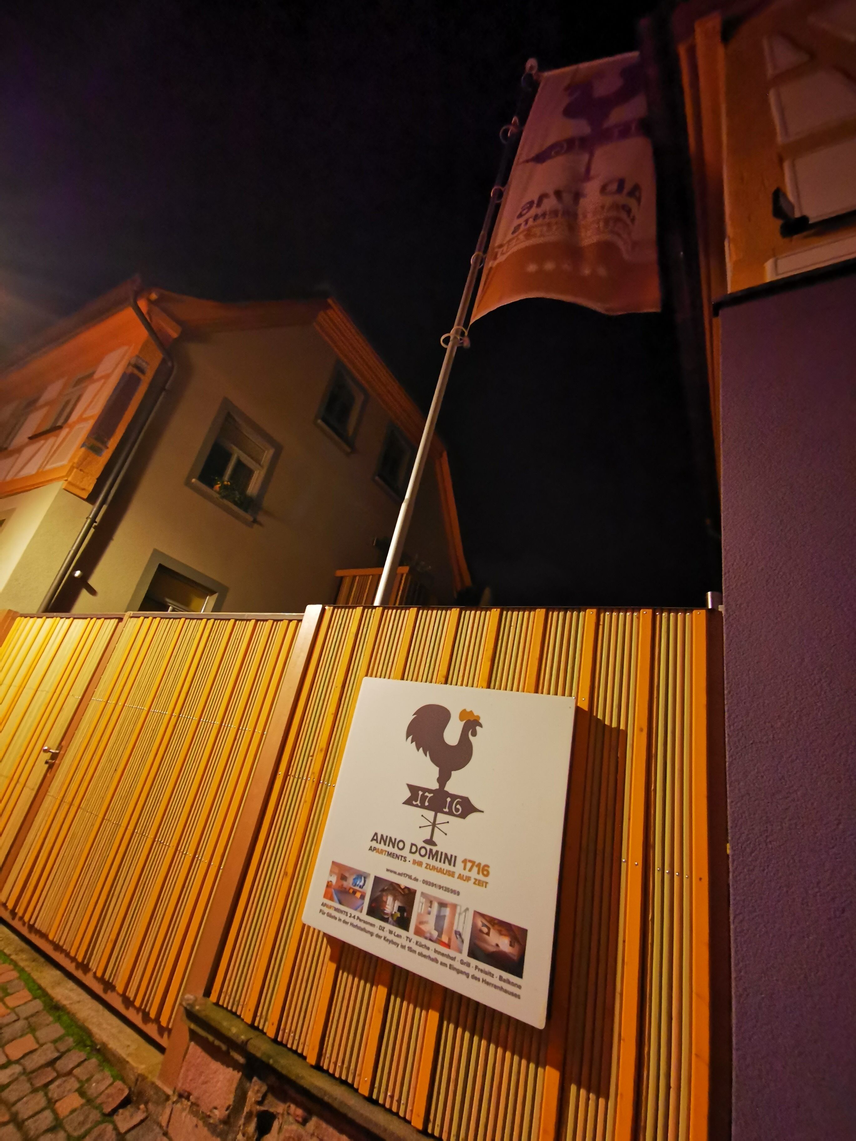 A sign with a rooster logo and text for 'Anno Domini 1716' and 'Mini Apartment'.