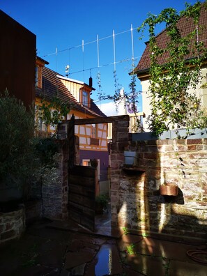 A courtyard with a wooden gate, stone walls, and a tiled roof. - Anno Domini 1716  Boutique Hotel (Marktheidenfeld)