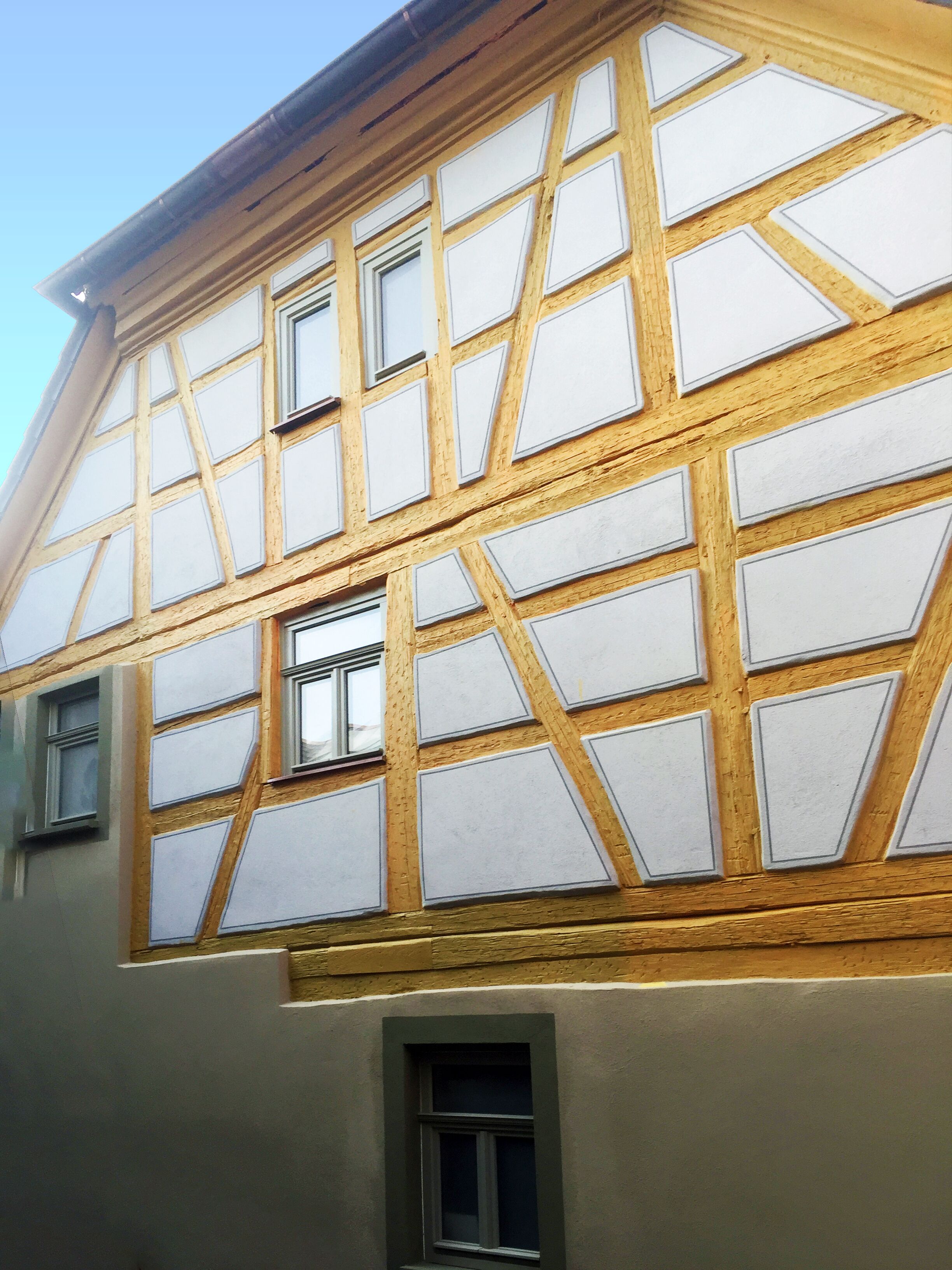 Un edificio de entramado madera con varias ventanas y un ático visible.