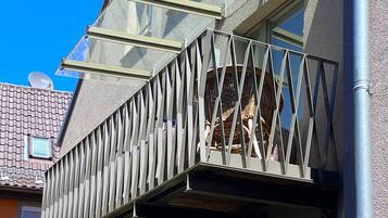 Un edificio moderno con un diseño de balcón único que incluye cerramientos de vidrio y barandillas de metal.