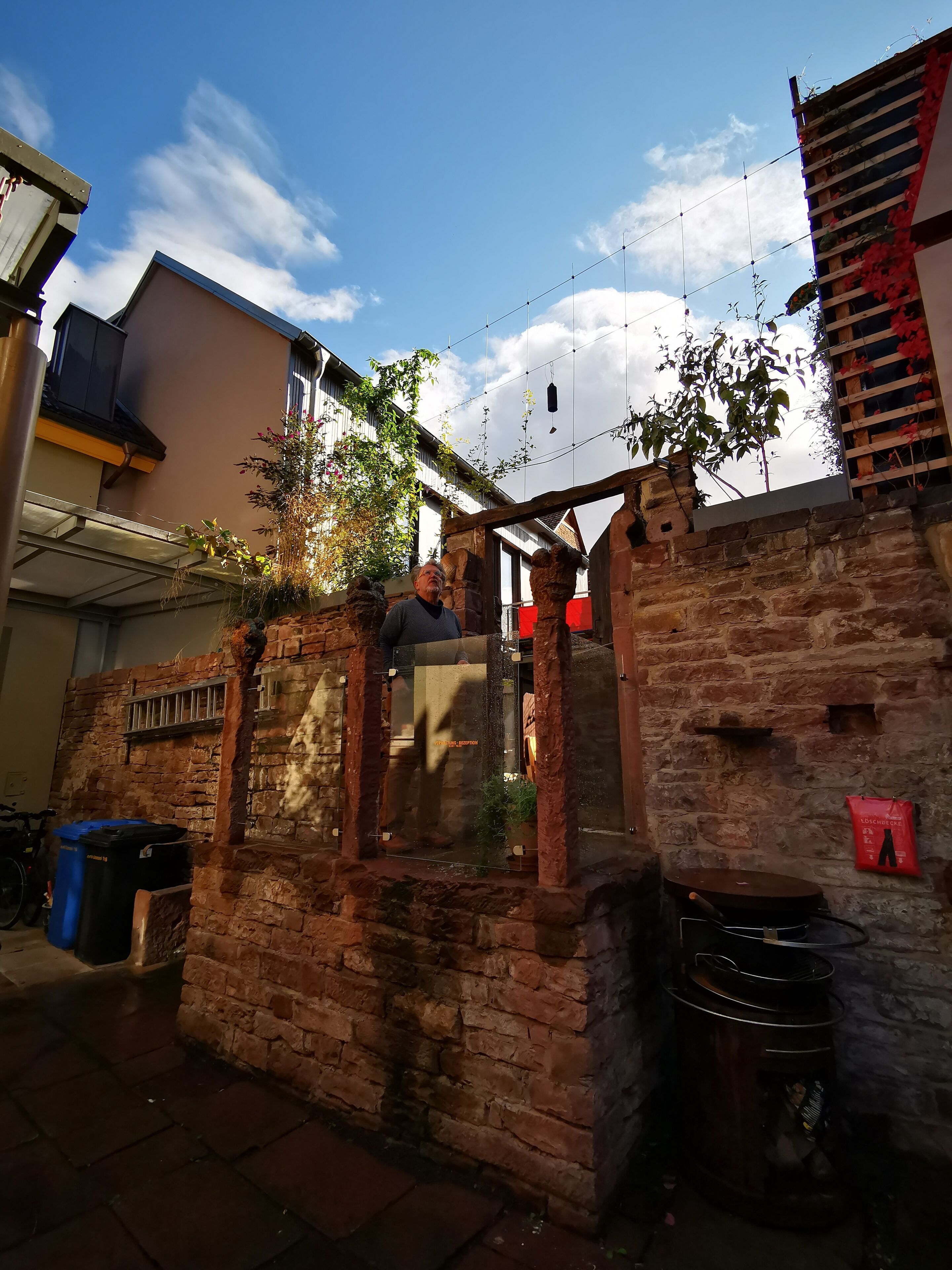 A rustic brick building with a wooden structure and a clear blue sky.