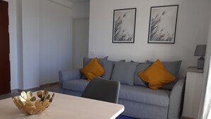 En stue med sofa, to puder, sofabord og lampe.