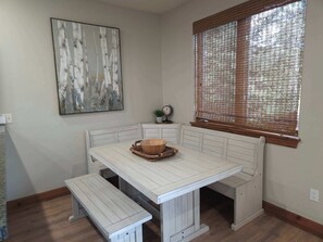 A corner dining area with a white wooden bench, a small table, and a woven basket. - Private Hot Tub, MountainScape Chalet! Paradise! (Breckenridge)