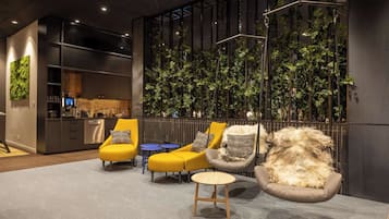 Un intérieur moderne comprenant des espaces de détente, une cuisine et un mur végétal vertical.