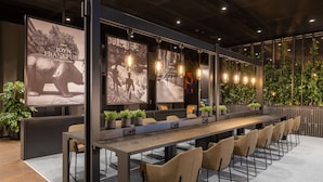 A modern conference room with a long table, chairs, and large posters on the walls. - Radisson Hotel & Suites Zurich (Opfikon)