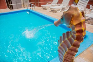 Una piscina con agua cristalina azul y una decoración de caballito de mar.