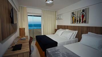 Habitación de hotel con dos camas, un escritorio con silla, televisión y un cuadro en la pared.