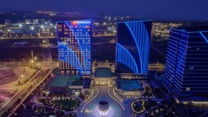 A Marriott hotel with a modern design, featuring a prominent blue facade and a central circular plaza.