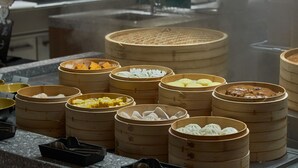 A variety of food items in bamboo steamers on a countertop.