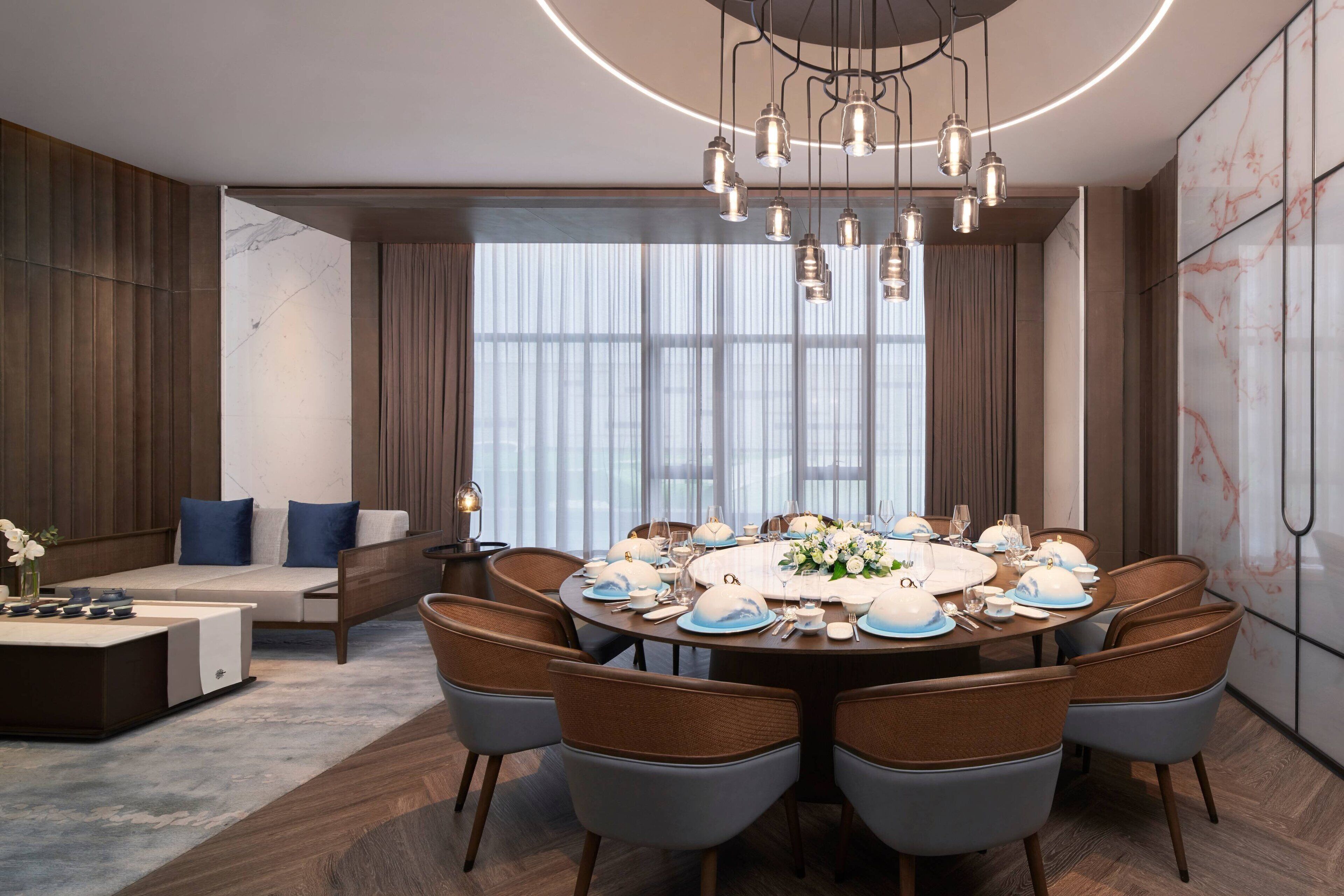Un espace repas moderne avec une table ronde pour six personnes, entourée de chaises rembourrées.
