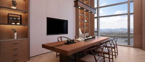 Un espace repas moderne avec une longue table en bois, des chaises et des étagères intégrées.