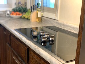 A kitchen with a built-in stovetop and wooden cabinets. - Quiet Lakefront Oasiswith hot tub and boat rental (Trevor)