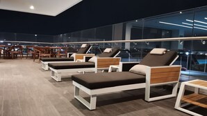 Un área de lounge en la azotea con sillones reclinables y una zona de comedor.