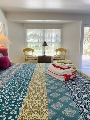 A hotel room with a bed, two chairs, a table with a lamp, and a window with blinds. - SeaTurtle đ˘Bayfront w/ heated pool, steps to Beach, Sleeps 10, Petsđž (Englewood)