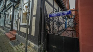 Una señal de calle con la inscripción "Sotelseleingang" y la entrada de un edificio con un portón negro.