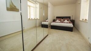 A bedroom with a large bed, a mirror, a radiator, and a window with blinds. - No 5 Central by Brighton Holiday Lets (Brighton)