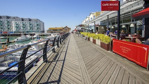 A wooden boardwalk with a cafe named 'Cafe Rouge' on the right.