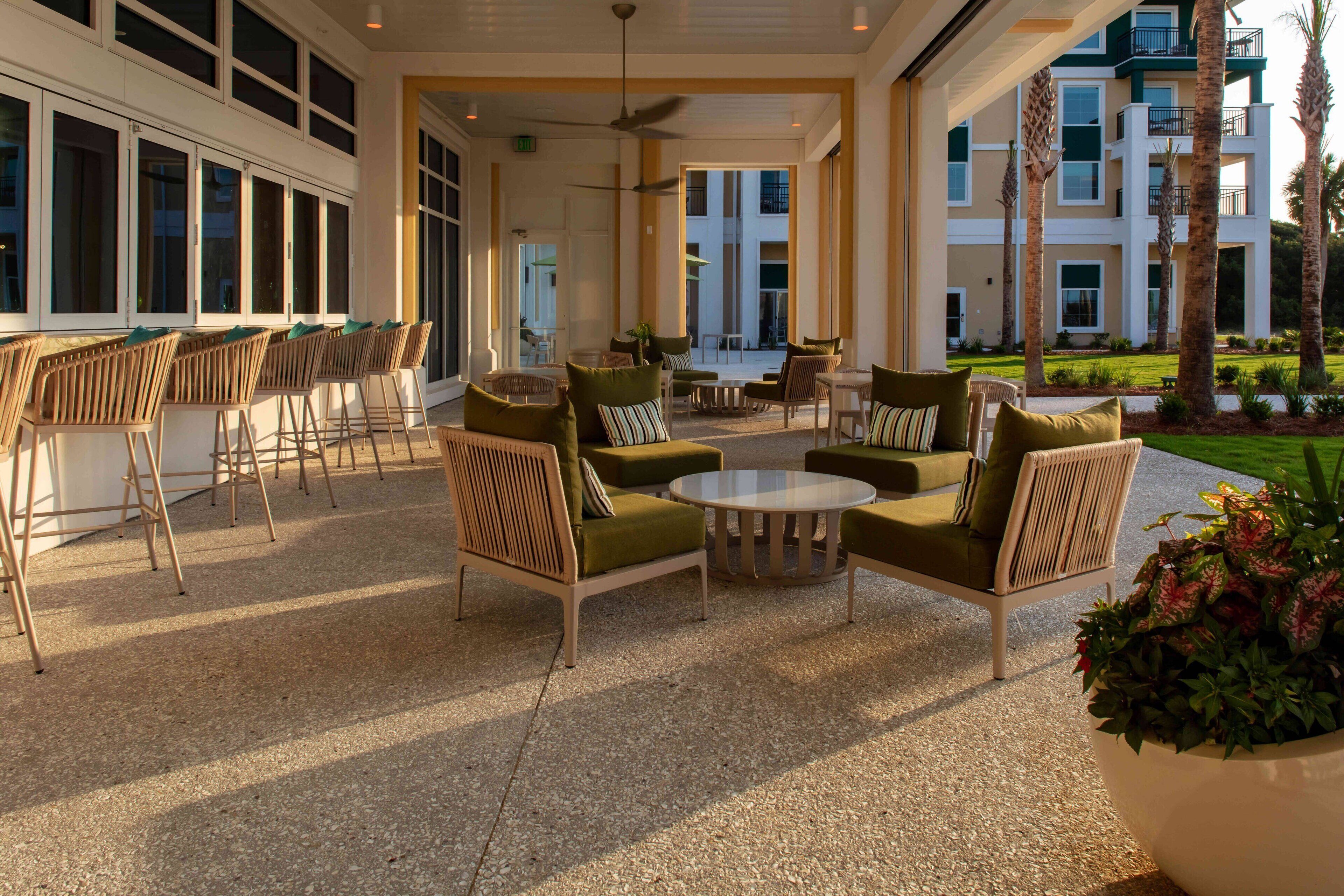 An outdoor patio area with seating arrangements and a view of a multi-story building.