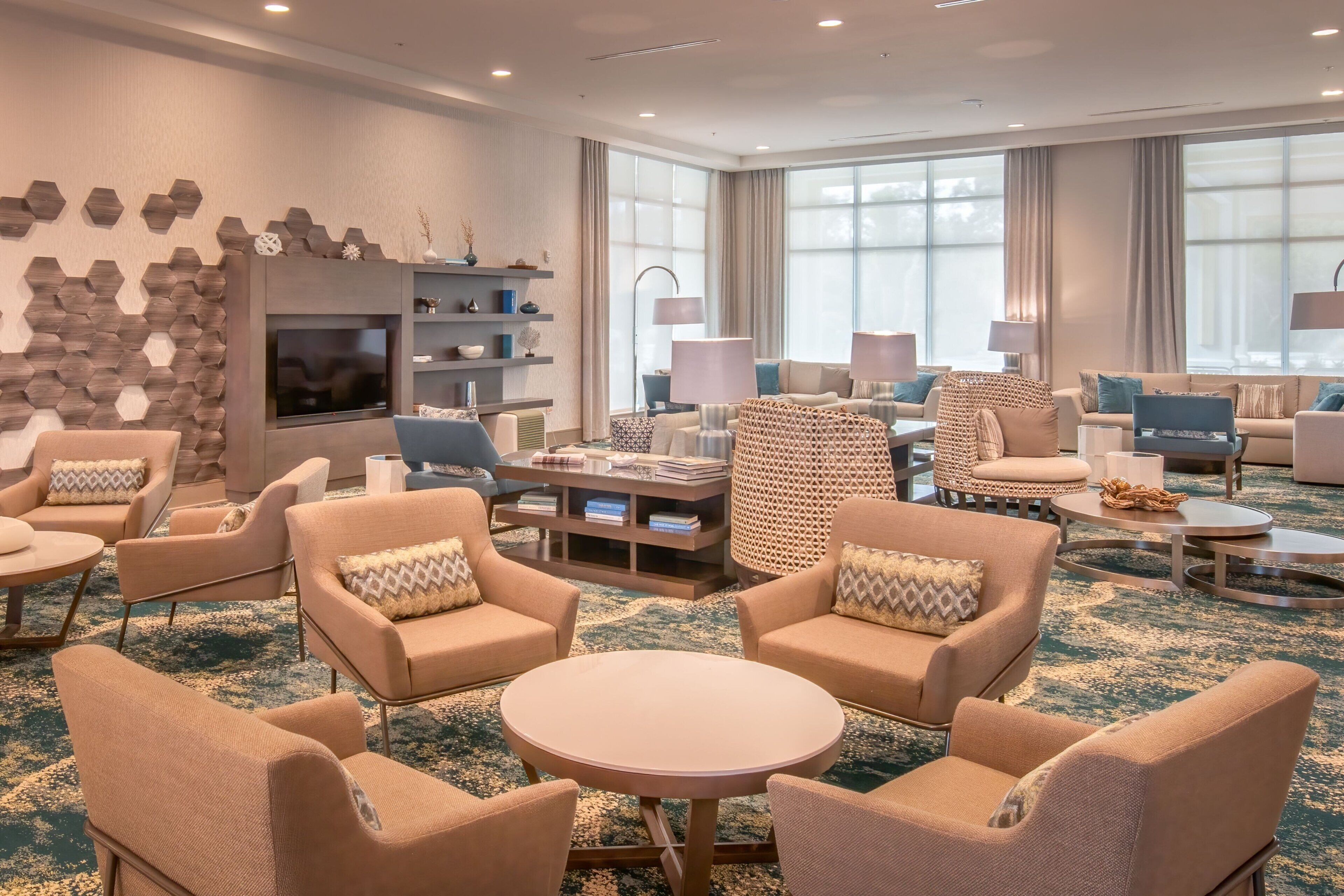 A spacious living room with a large TV, comfortable seating, and a decorative wall.