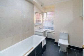 Une salle de bain avec une baignoire, des toilettes et un lavabo.