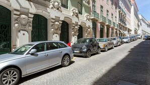 A row of parked cars along a cobblestone street with ornate buildings featuring classical architectural details. - Bright and Spacious 1 Bed Apartment near Baixa (Lisboa)