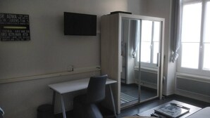 Ein Hotelzimmer mit Schreibtisch, Stuhl und Schiebetürenschrank.