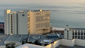Ein Hochhotel mit mehreren Etagen, einem Dachpool und Blick auf den Ozean.