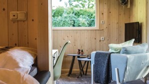 Een knus ingerichte kamer met een bed, een klein tafeltje met stoelen en een bank.