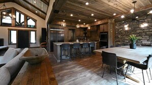 Un'ampia cucina con isola centrale, sgabelli da bar e tavolo da pranzo con sedie.