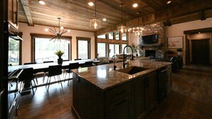 Un'ampia cucina con una grande isola, soffitto in legno e ampie finestre.