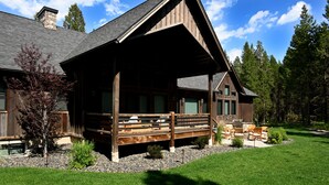 Un lodge con un portico coperto, posti a sedere all'aperto e un camino in pietra.