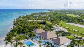 An aerial view of a resort with a large building, a swimming pool, and a beach. - Luxury Sunshine II. villa with SEA & GOLF VIEW, pool heated, CHEF & staff incl. (Punta Cana)