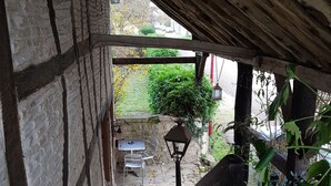 A wooden staircase leading to an outdoor seating area with a table and chairs. - Bienvenue à l'escale (Gigny-sur-Saône)