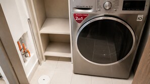 A front-loading washing machine with a control panel, a red '2en1' label, and a 'Direct Drive 10.1' label. - Stunning Hi-Rise high speed WiFi , minimalist chic decor, with all the amenities (Ciudad de México)