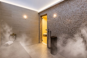 Une salle de bain moderne avec une douche, un porte-serviettes et un mur orné d’un motif en mosaïque.