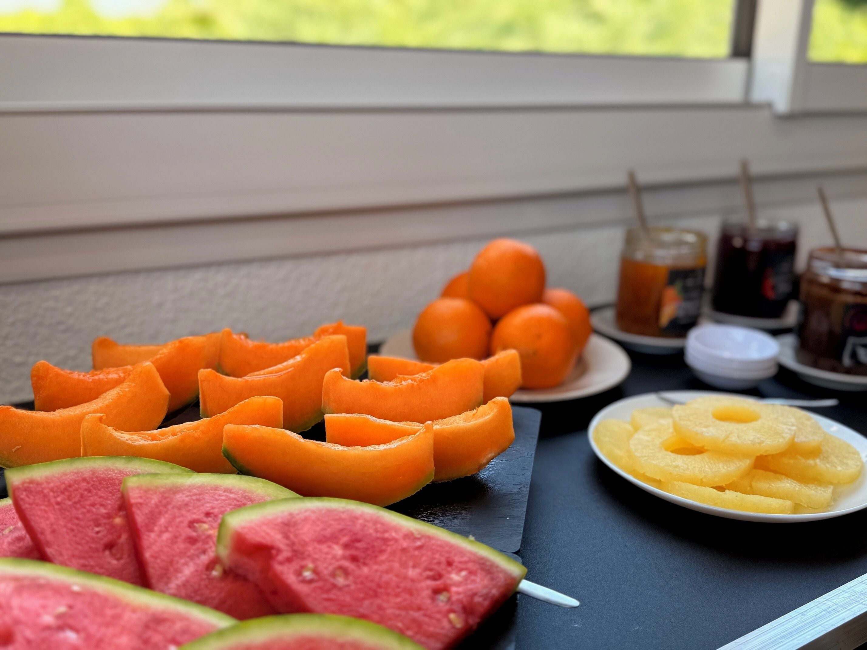 A table with sliced fruits and beverages.