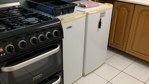 A kitchen with a black stove, a white refrigerator, and wooden cabinets. - 2bed Room Small Annex Furnished in High Wycombe (High Wycombe)