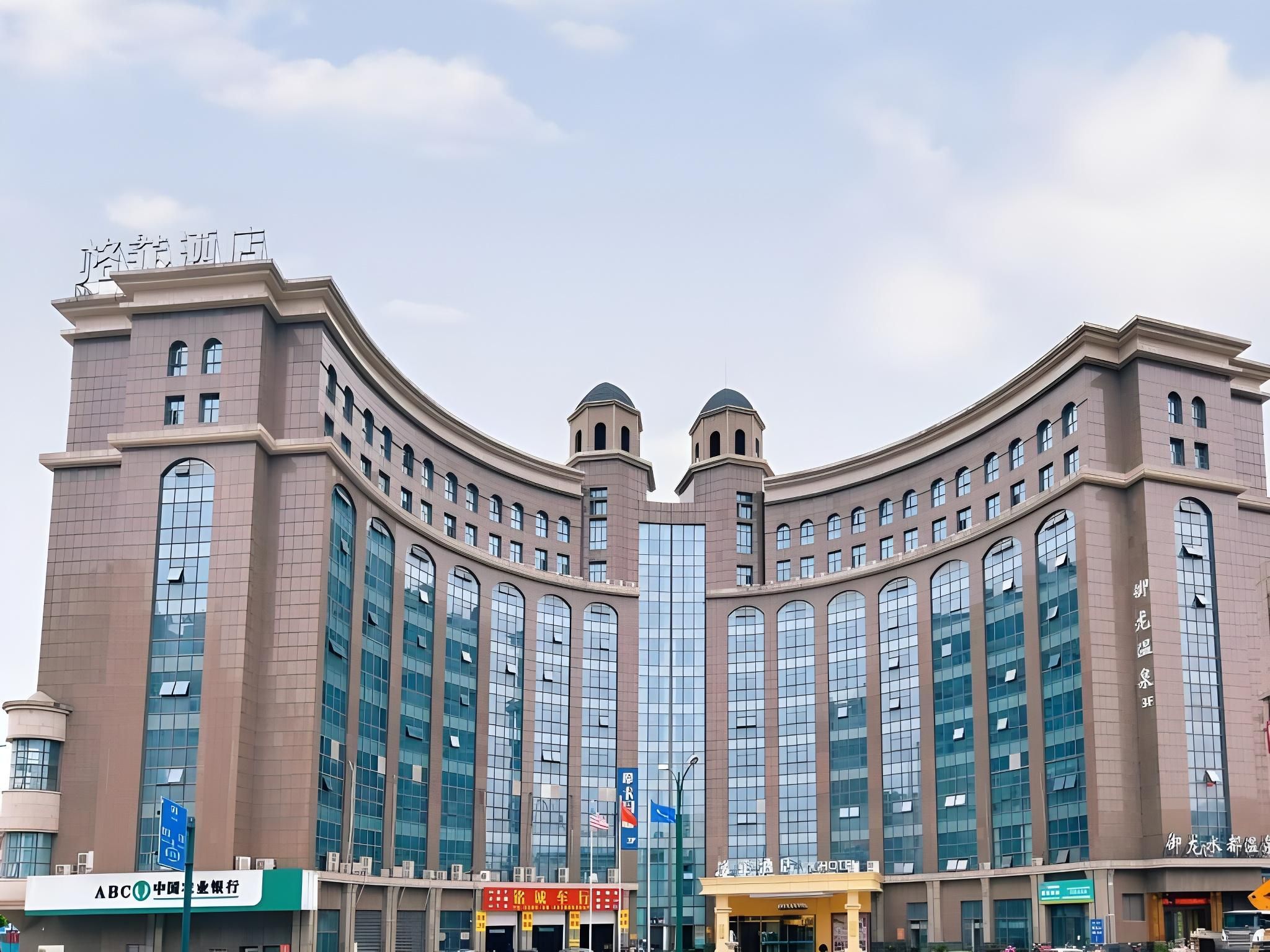 Ein großes, modernes Gebäude mit einer geschwungenen Fassade, zahlreichen Fenstern und einem markanten Eingang.