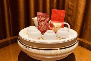 A decorative bowl with a white and gold design, placed on a wooden table. - Ruiting Hotel (Zhongshan Xiaolan Daxin Xinduhui Branch) (Zhongshan)