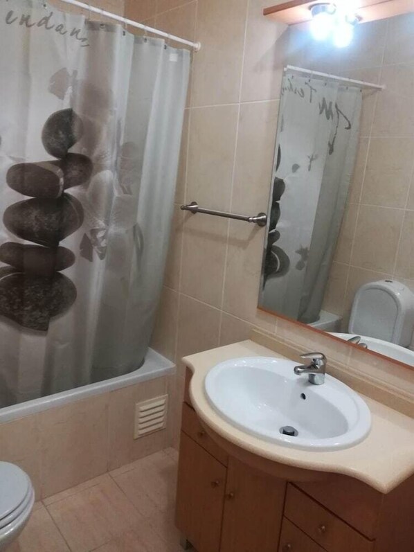 A bathroom with a bathtub, a sink, and a toilet. - Jardins Vale de Parra (Albufeira)