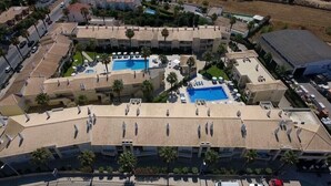 A resort with multiple swimming pools, palm trees, and a central courtyard. - Jardins Vale de Parra (Albufeira)