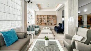 A modern living room with a sofa, armchairs, a coffee table, and a bookshelf. - Atlantica Sea Breeze - Adults Only (Paralimni)