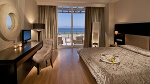 A hotel room with a bed, desk, chair, and a view of the sea. - Kipriotis Panorama and Suites (Kos)