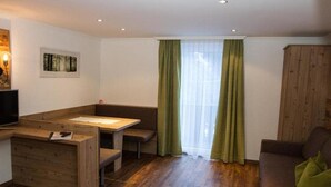 Un espace de vie compact comprenant un banc en bois servant de siège, une petite table et un canapé.