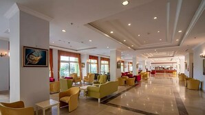 A spacious lobby with multiple seating areas, a reception desk, and large windows allowing natural light. - Miarosa Konakli Garden (Alanya)