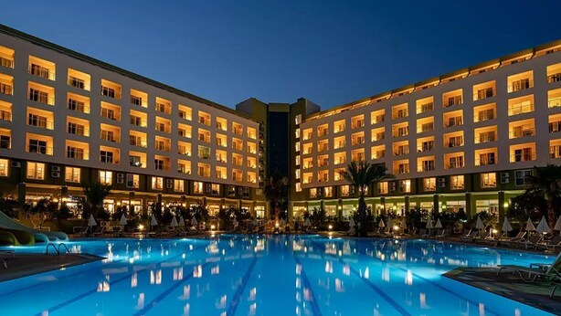 A hotel with a large pool, multiple floors, and a well-lit facade. - Miarosa Konakli Garden (Alanya)