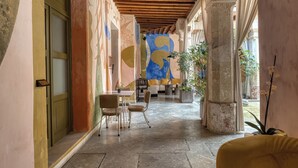 A corridor with a wooden ceiling, stone flooring, and a colorful mural on the wall. - Pug Seal Oaxaca (Oaxaca)