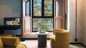 A room with a large window, a round table, and two yellow armchairs. - Pug Seal Oaxaca (Oaxaca)
