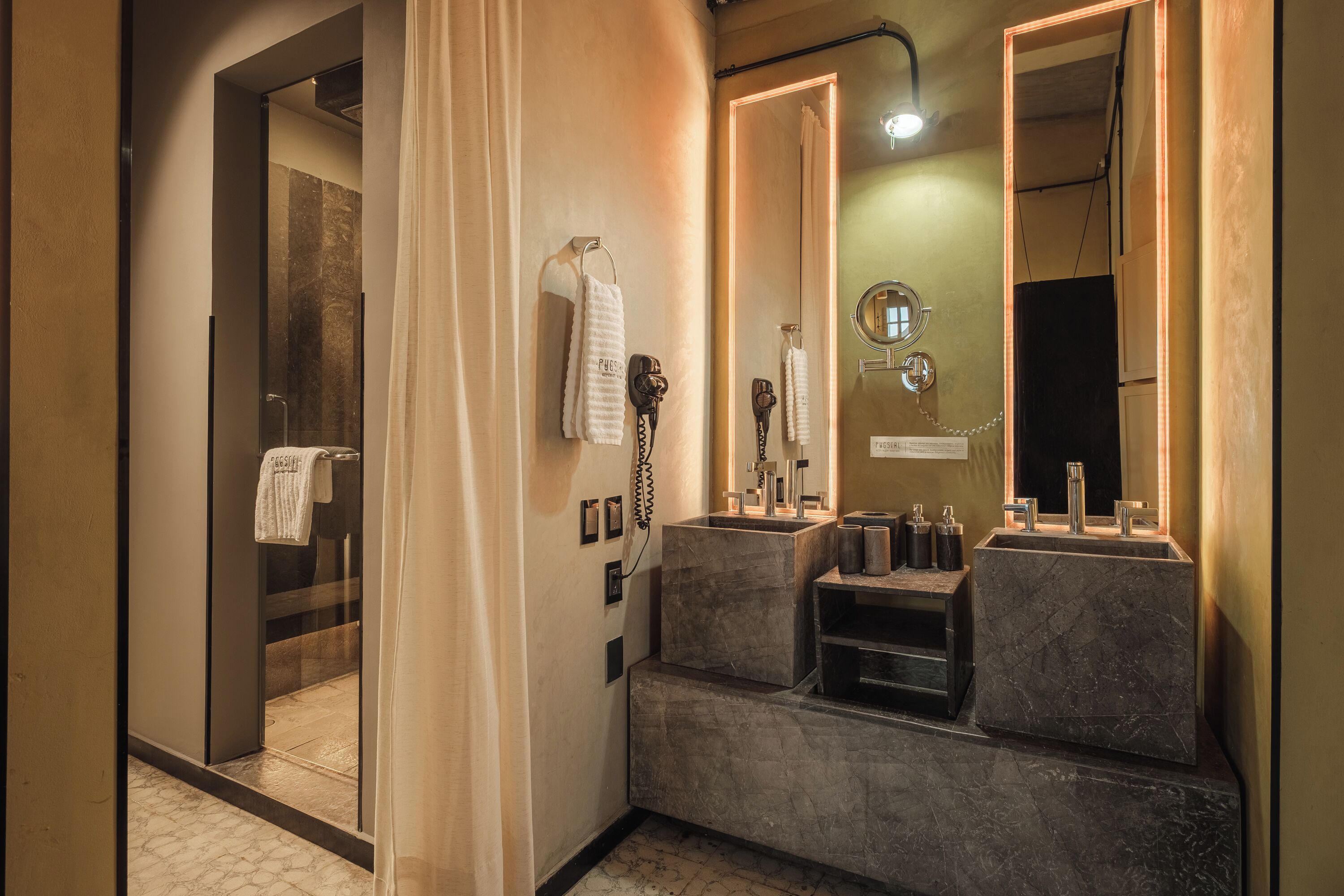 A modern bathroom with a glass shower enclosure, a vanity with two sinks, and a large mirror.