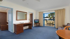 A hotel room with a desk, television, and a balcony with outdoor seating. - Cairns Southside International (Cairns)